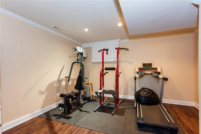 exercise area with ornamental molding and dark hardwood / wood-style floors