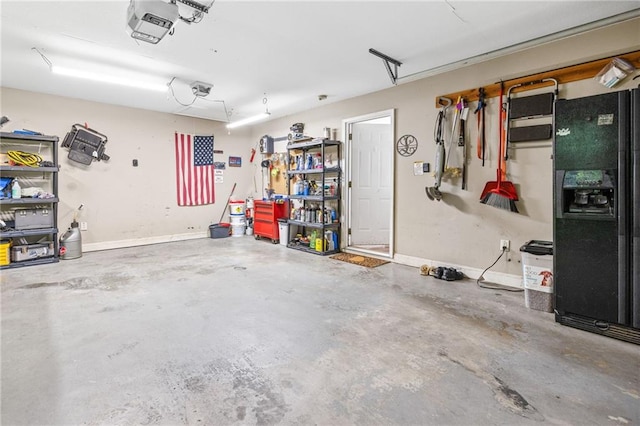 253 Grindstone Creek Dr, Clarkesville, GA 30523 - garage with black refrigerator with ice dispenser, a garage door opener, and baseboards