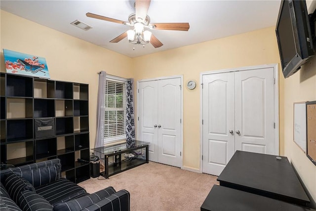 sitting room featuring baseboards, light carpet, a ceiling fan, and visible vents