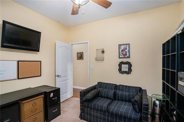 living area with carpet floors, ceiling fan, and baseboards