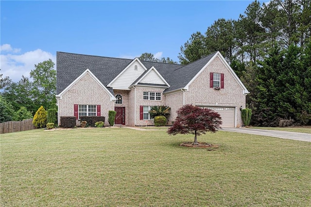 traditional-style house with fence, a front yard, brick siding, an attached garage, and driveway
