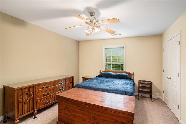 carpeted bedroom with baseboards, ceiling fan, a closet, and visible vents
