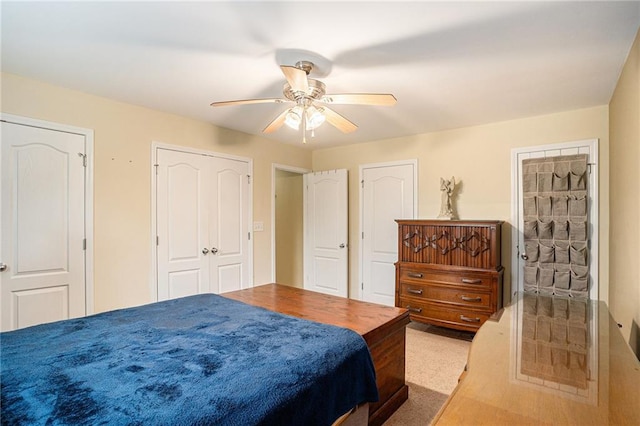 carpeted bedroom with multiple closets and ceiling fan