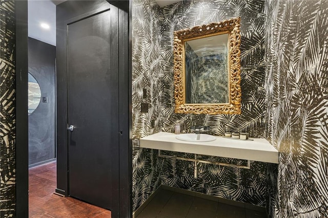 bathroom with a sink and wallpapered walls