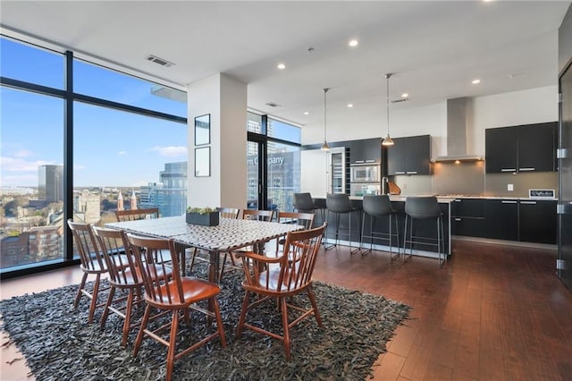 dining space featuring dark wood-style floors, a healthy amount of sunlight, floor to ceiling windows, and visible vents