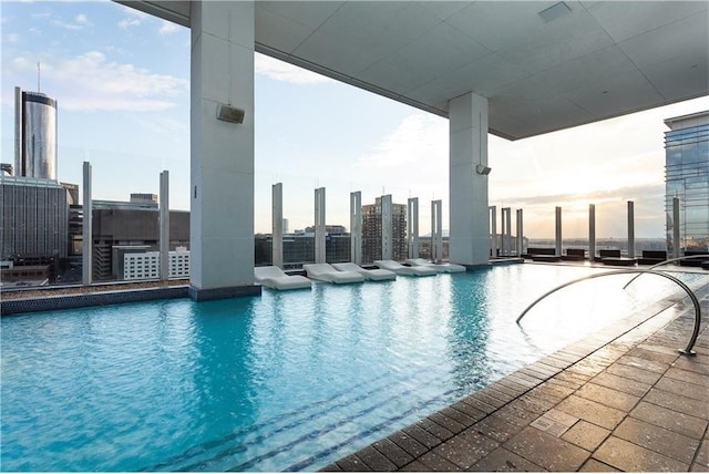 pool at dusk featuring a city view