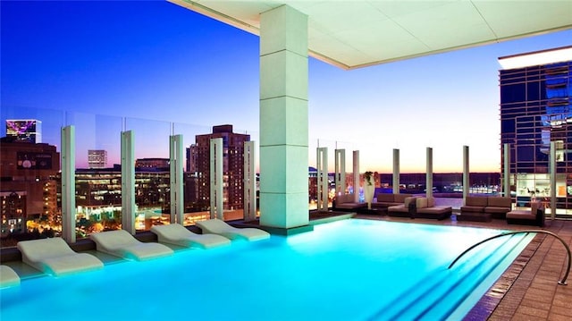 view of swimming pool featuring a view of city and an outdoor living space