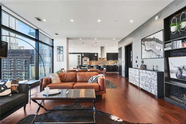 living area featuring expansive windows, dark wood finished floors, visible vents, and recessed lighting