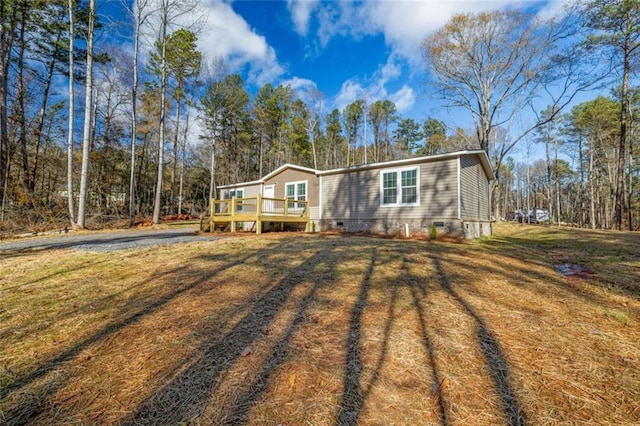 view of front of property featuring a front yard and a wooden deck