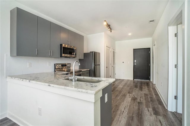 kitchen with visible vents, dark wood-style floors, appliances with stainless steel finishes, a peninsula, and decorative backsplash