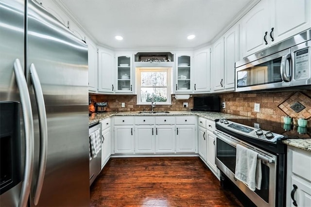2057 High Shoals Rd, Dallas, GA 30132 - kitchen featuring appliances with stainless steel finishes, glass insert cabinets, light stone countertops, dark wood finished floors, and white cabinetry