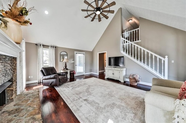 2057 High Shoals Rd, Dallas, GA 30132 - living room with a stone fireplace, ceiling fan, stairs, high vaulted ceiling, and dark wood-style floors
