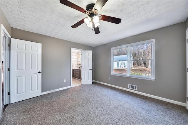 2057 High Shoals Rd, Dallas, GA 30132 - unfurnished bedroom with carpet floors, a textured ceiling, connected bathroom, and ceiling fan