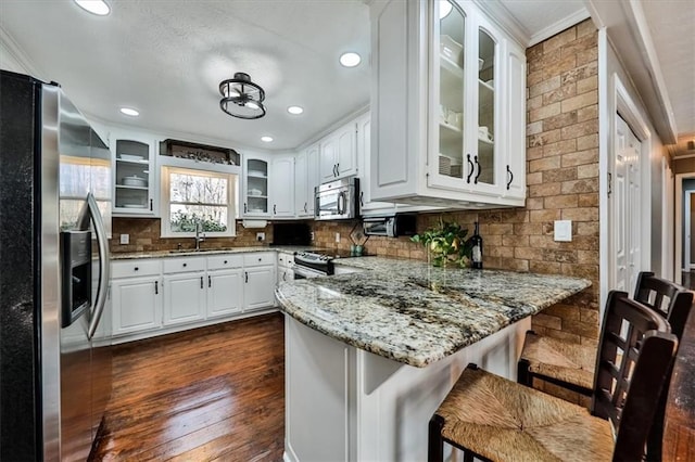 2057 High Shoals Rd, Dallas, GA 30132 - kitchen featuring appliances with stainless steel finishes, a peninsula, ornamental molding, light stone counters, and backsplash