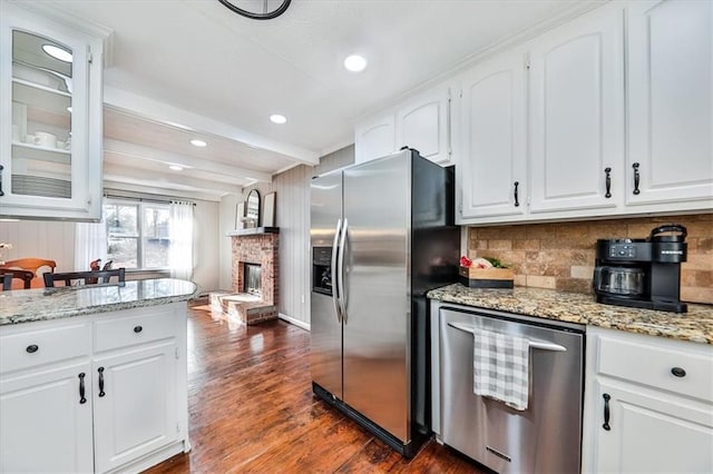 2057 High Shoals Rd, Dallas, GA 30132 - kitchen featuring appliances with stainless steel finishes, dark wood-style floors, white cabinets, a brick fireplace, and beam ceiling
