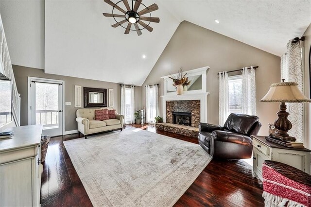 2057 High Shoals Rd, Dallas, GA 30132 - living room featuring a ceiling fan, a stone fireplace, high vaulted ceiling, dark wood-style flooring, and recessed lighting