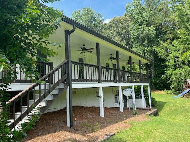 2057 High Shoals Rd, Dallas, GA 30132 - back of house featuring a ceiling fan, a lawn, a playground, stairs, and a wooden deck