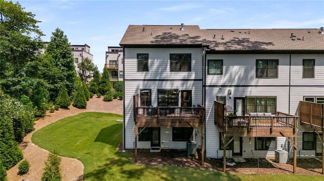 back of property featuring a wooden deck, central AC, and a lawn