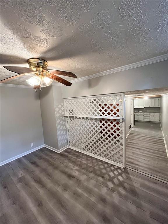 interior space featuring ceiling fan, crown molding, dark wood-type flooring, and a textured ceiling