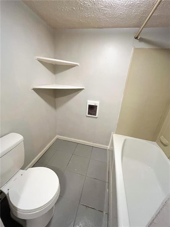 bathroom with tile patterned floors, toilet, and a textured ceiling