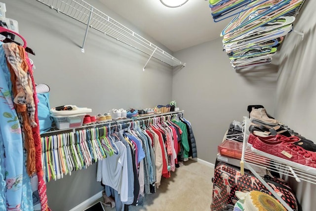 walk in closet featuring light carpet