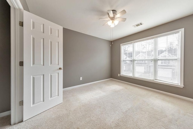 carpeted spare room with ceiling fan