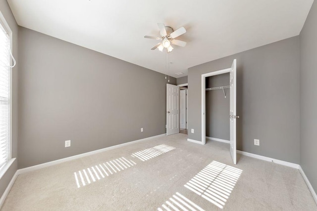 unfurnished bedroom featuring ceiling fan, light colored carpet, and a closet