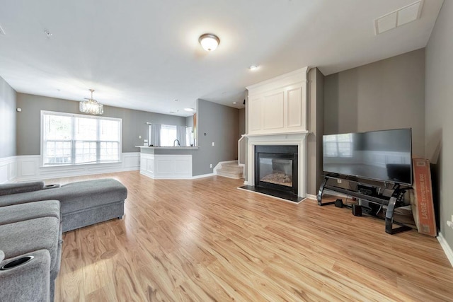 living room featuring light wood-type flooring and a chandelier