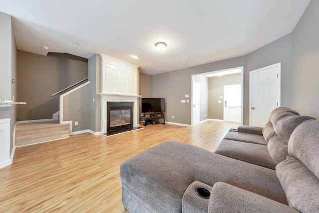 living room with a large fireplace and light wood-type flooring