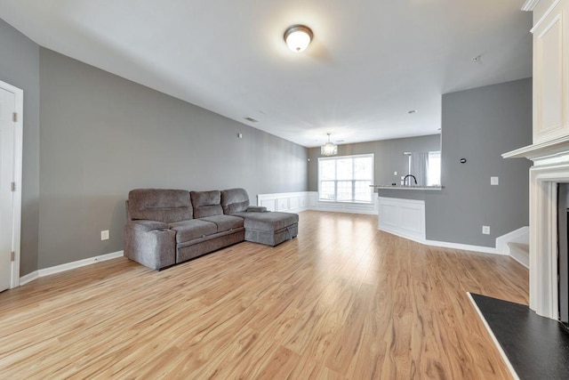 living room with an inviting chandelier and light hardwood / wood-style flooring