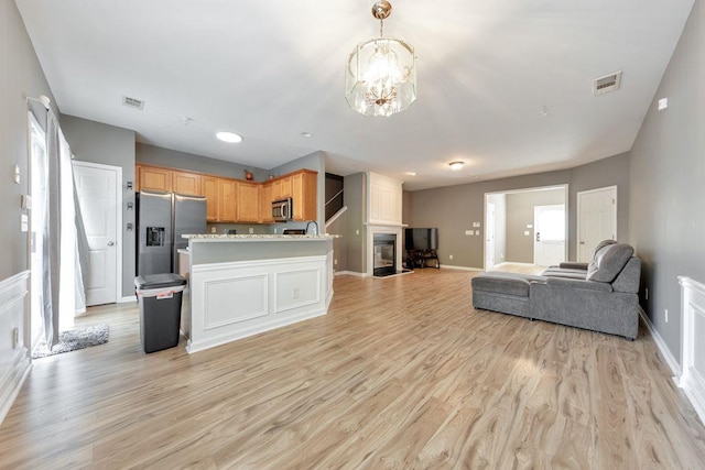 kitchen featuring a chandelier, light brown cabinets, light wood-type flooring, and stainless steel appliances