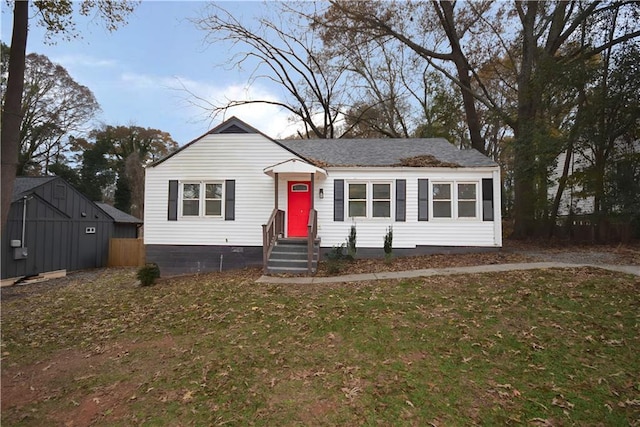 view of front of house featuring a storage unit and a front yard