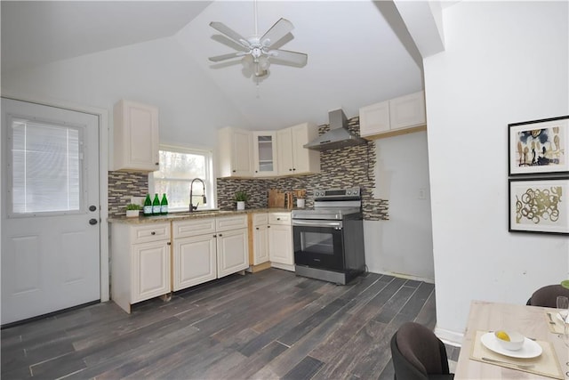 kitchen featuring dark wood-type flooring, high vaulted ceiling, wall chimney range hood, sink, and electric range