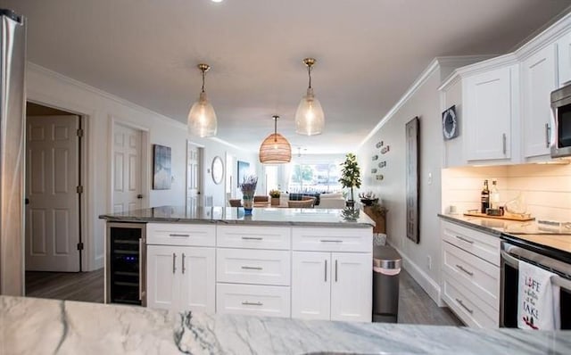 kitchen with white cabinetry, hanging light fixtures, wine cooler, tasteful backsplash, and light stone countertops