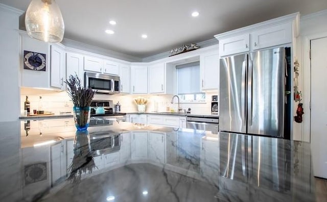 kitchen with sink, crown molding, dark stone counters, stainless steel appliances, and white cabinets