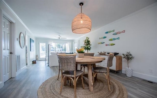 dining space with crown molding and wood-type flooring