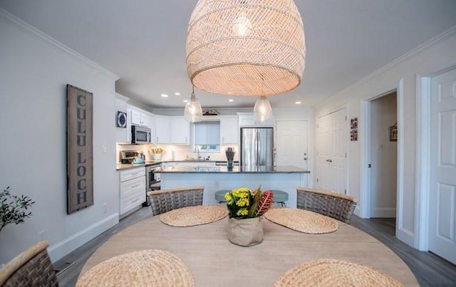 dining room with crown molding, sink, and dark wood-type flooring