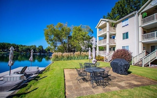 view of patio with grilling area and a water view