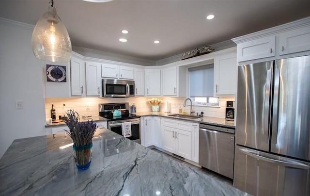 kitchen featuring sink, decorative light fixtures, appliances with stainless steel finishes, dark stone counters, and white cabinets