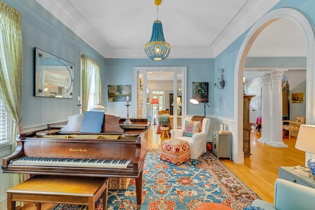 misc room with plenty of natural light, light wood-type flooring, and ornate columns