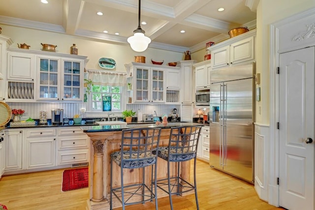 kitchen with built in appliances, light hardwood / wood-style flooring, a kitchen island, and coffered ceiling