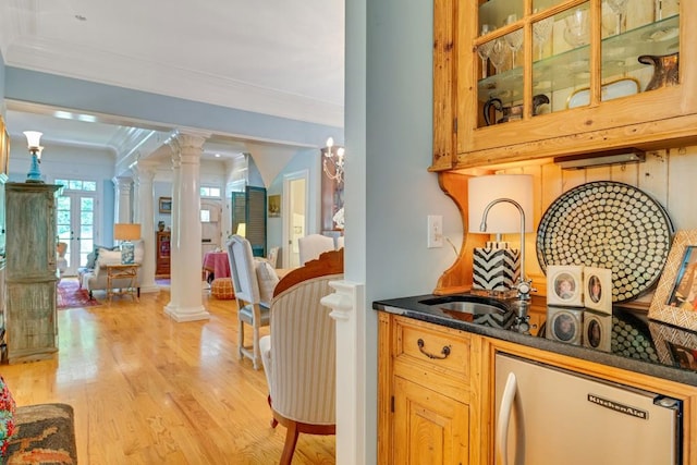 bar with decorative columns, dishwasher, light hardwood / wood-style flooring, and crown molding