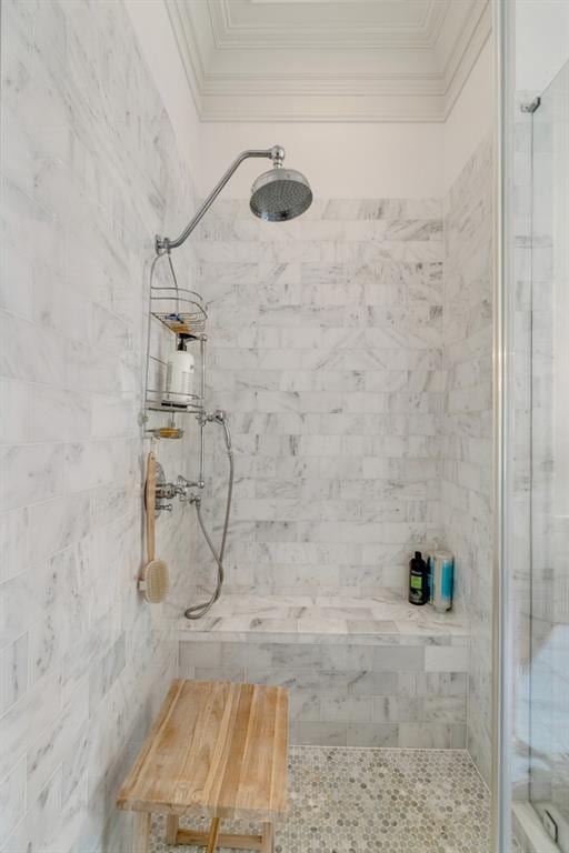 bathroom with tiled shower, tile walls, and ornamental molding