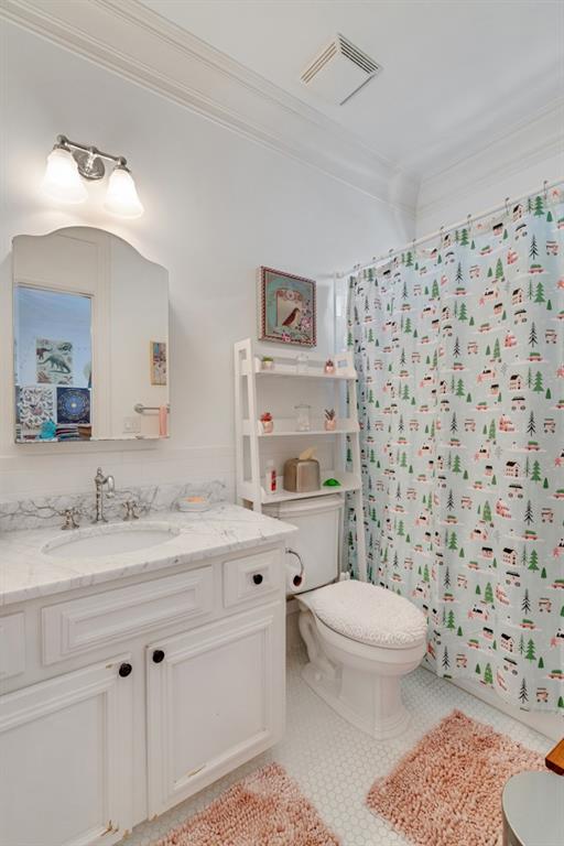 bathroom with vanity, toilet, tile patterned floors, and crown molding