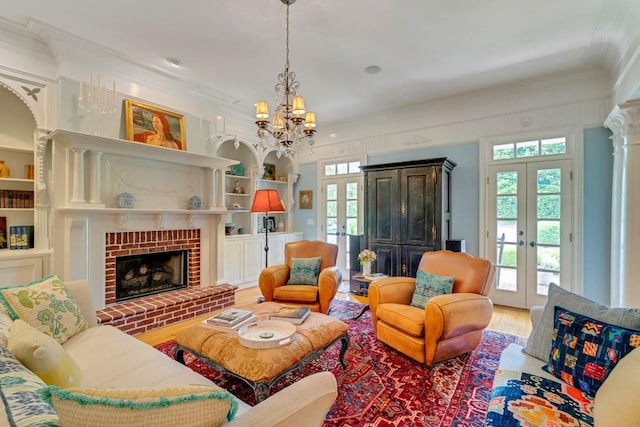 living room with french doors, a chandelier, a fireplace, hardwood / wood-style flooring, and ornamental molding