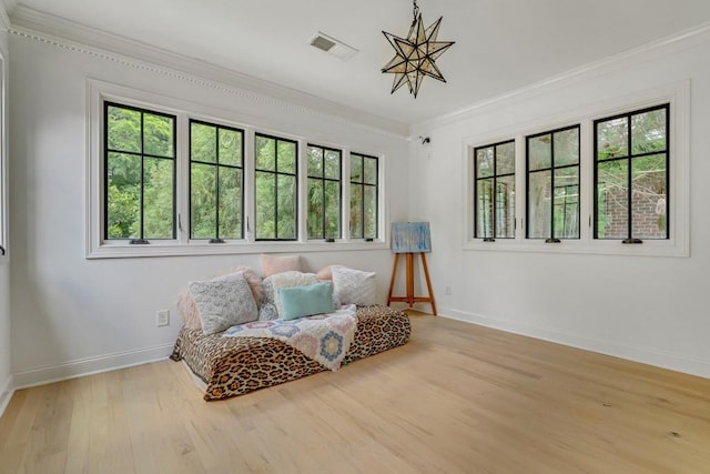 sitting room featuring ornamental molding and light hardwood / wood-style floors