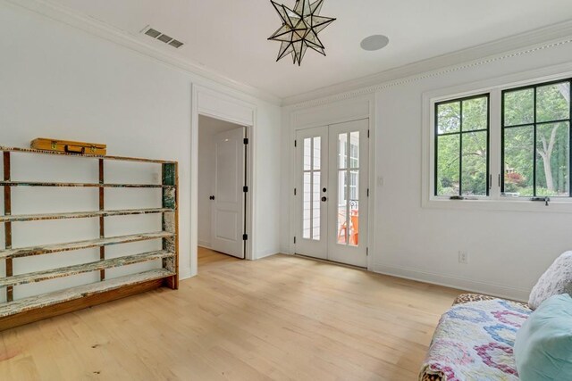 interior space with french doors, light wood-type flooring, and ornamental molding