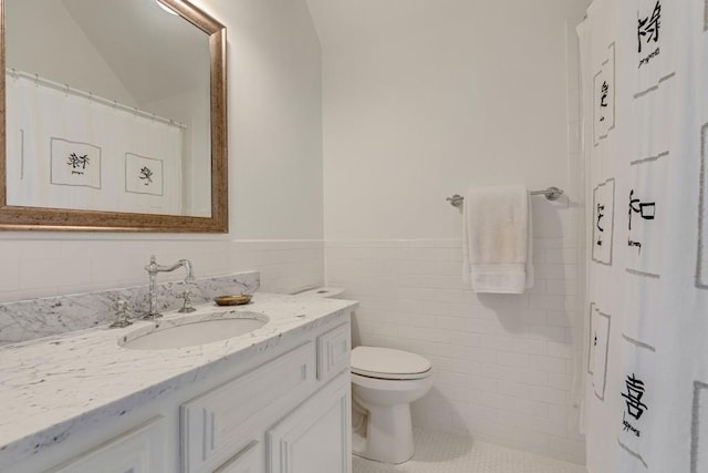 bathroom featuring tile walls, toilet, and vanity