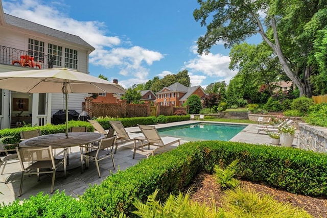 view of swimming pool featuring a patio and grilling area