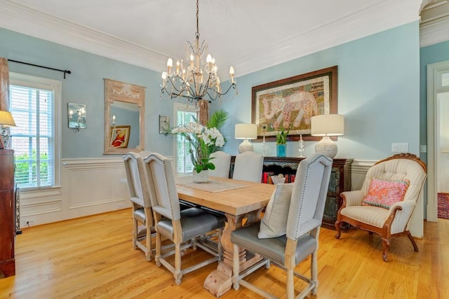 dining space with a chandelier, crown molding, and light wood-type flooring